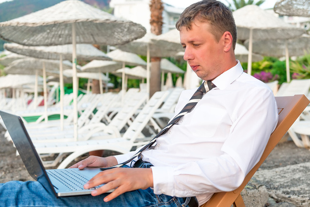 Менеджер, що працює на ноутбуці на пляжі
 - Фото, зображення