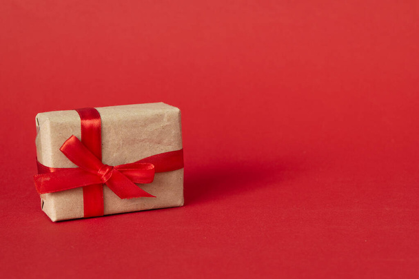 gift box with red ribbon bow on red background. present for Christmas, new year, valentine day, copy space - 写真・画像