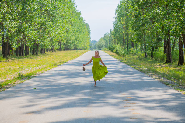 perky girl on the road with a suitcase goes. High quality photo - Photo, Image