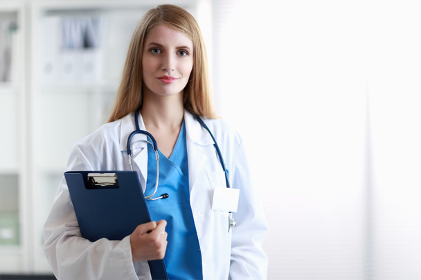 Portrait of woman doctor with folder at hospital corridor - Foto, immagini