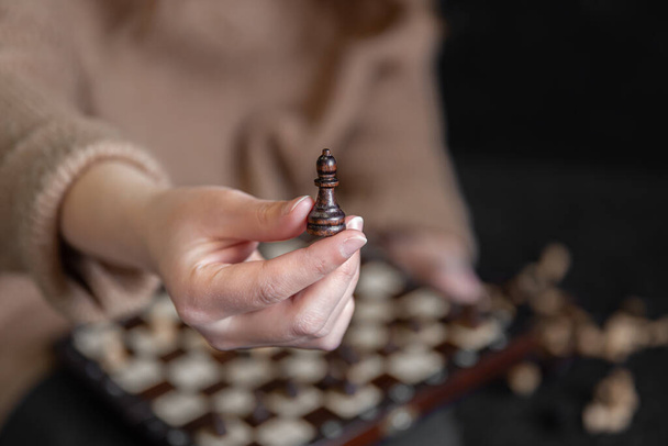 Close-up de uma peça de xadrez em mãos femininas, fundo borrado. - Foto, Imagem