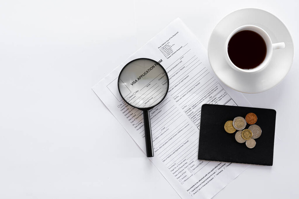 Formulaire de demande de visa, documents et une tasse de café sur fond blanc. - Photo, image