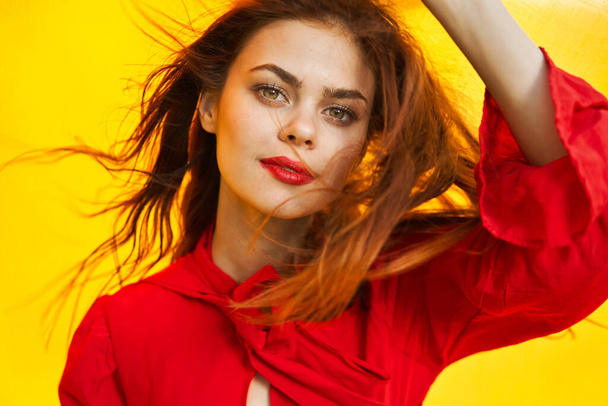 cheerful woman in red dress posing in nature yellow cloth - Foto, afbeelding