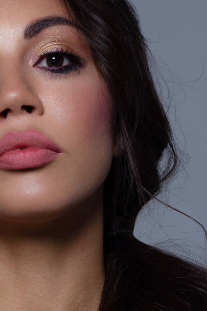 Half the face of a young sexy woman with pink lipstick on her lips and black eyeliner. Classic makeup and straight long hair. Evening make-up, cosmetology, spa, cosmetics, rejuvenation - Photo, Image