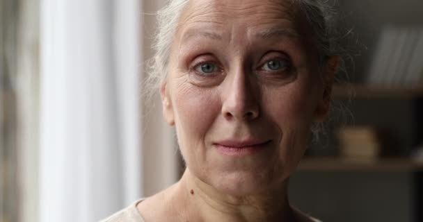 zbliżenie portret szczęśliwy kobieta emeryt patrzeć w aparat z uśmiechem - Materiał filmowy, wideo