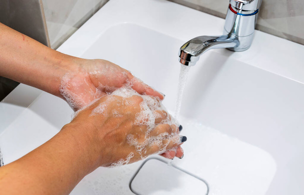 A woman washes her hands with liquid soap and clean water. Wash your hands to keep them clean. - Photo, Image