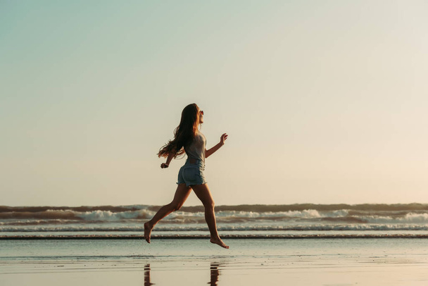 Happy beautiful girl walks at sea beach - Zdjęcie, obraz