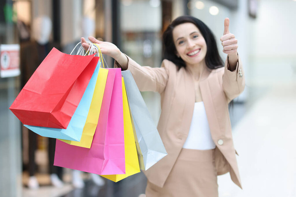 Happy woman in shopping mall with packages, close-up - Fotografie, Obrázek