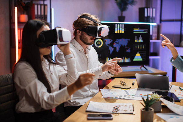 Multiracial business colleagues wearing VR goggles at office - Foto, Imagem