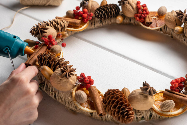 Componenti naturali ghirlanda. Le mani della donna che fanno naturale eco decorazione di Natale - Foto, immagini