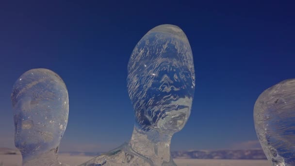 Des sculptures de glace. Des têtes humaines abstraites. Figures glaciales debout sur le ciel bleu.  - Séquence, vidéo