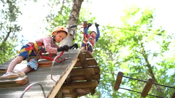 Little boy climbed to the top of the climbing wall, rearranging the carbines - Footage, Video