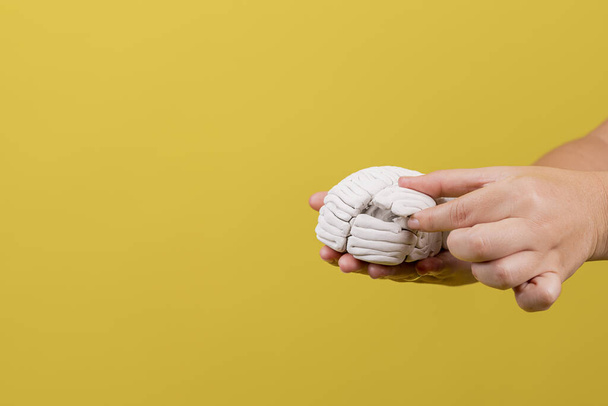 A hand putting a piece of a damaged brain back - Zdjęcie, obraz