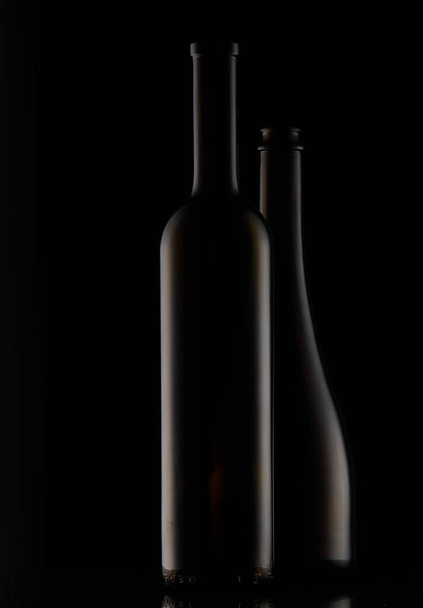 A vertical shot of bottles on a dark background - Foto, imagen