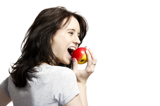 Молода жінка кусає червоне яблуко
 - Фото, зображення
