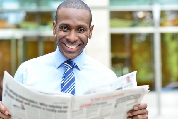 Smiling executive holding newspaper - Zdjęcie, obraz