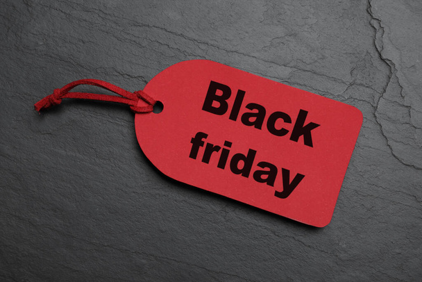 Red tag on dark stone background, top view. Black Friday sale - Foto, immagini