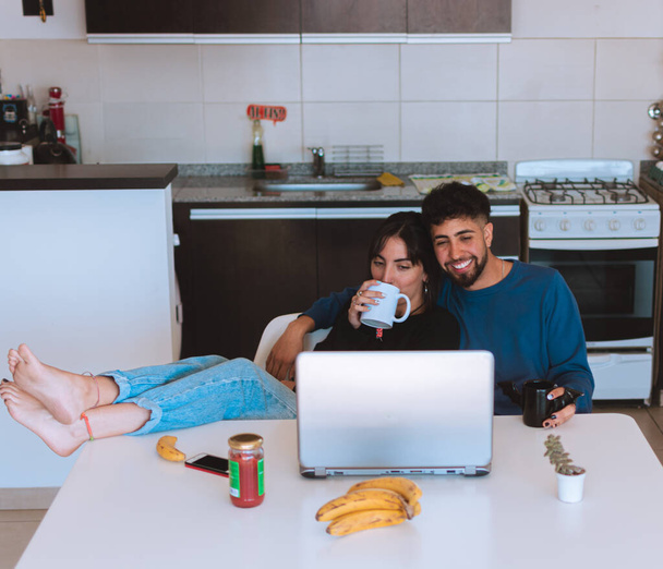 A beautiful shot of Hispanic couple sitting and drinking coffee together in the kitchen in Argentina - Foto, Imagem
