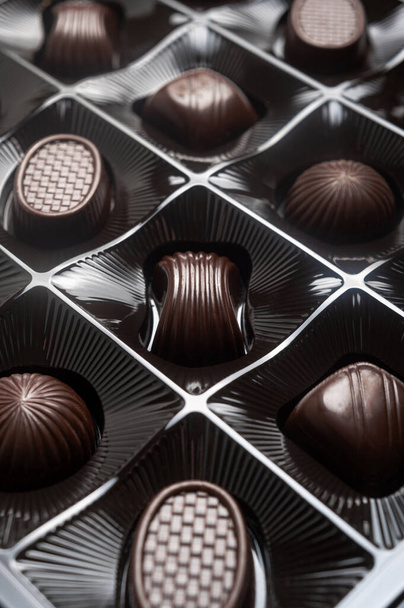 Dulces de chocolate amargo oscuro en una caja. El postre dulce es dulce. Surtido de lujo de dulces - Foto, Imagen