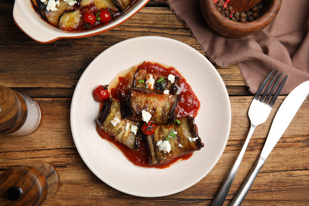 Tasty eggplant rolls served on wooden table, flat lay - Foto, Imagen