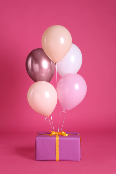 One gift box and balloons near bright pink background - Φωτογραφία, εικόνα