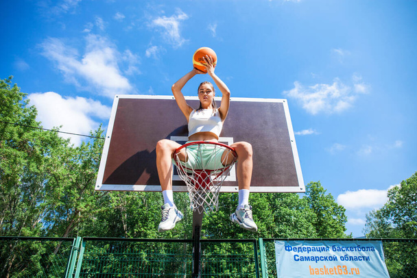 Young beautiful brunette girl posing on the basketball court - Zdjęcie, obraz