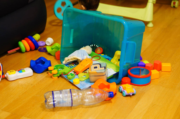 POZNAN, POLAND - Jan 17, 2015: A plastic container laying on the floor with assorted toys - Фото, изображение