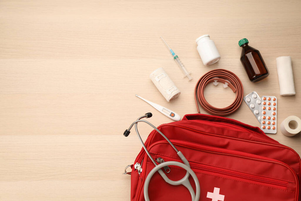 First aid kit on light wooden table, flat lay. Space for text - Fotoğraf, Görsel
