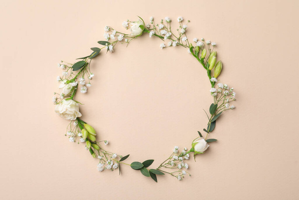 Frame made of beautiful gypsophila, roses, eucalyptus and freesia on beige background, top view. Space for text - Photo, image