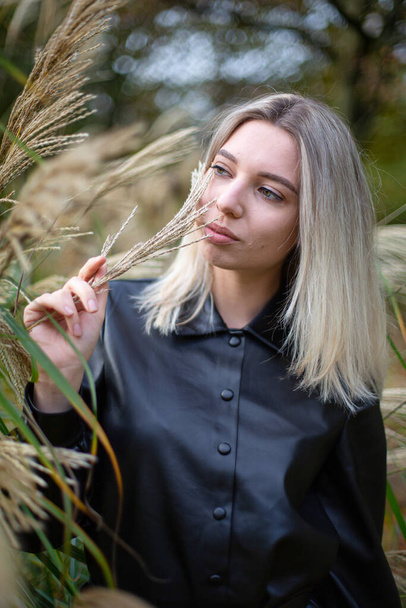 Blond young woman in black autumn dress portrait - Fotó, kép