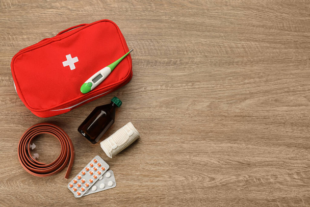 First aid kit on wooden table, flat lay. Space for text - 写真・画像