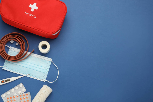 Flat lay composition with first aid kit on blue background, space for text - Foto, imagen