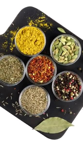 Different indian spices and herbs rotated on white background in glass bowls. - Footage, Video