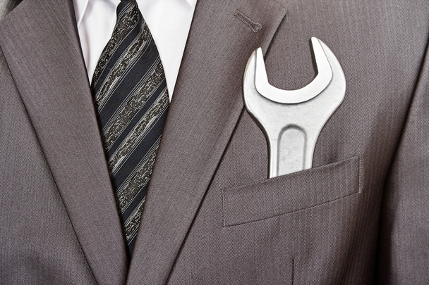 Spanner in businessman suit pocket - Photo, Image