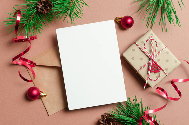 Christmas or New Year greeting card mockup with gift box, envelope and festive decorations - Valokuva, kuva