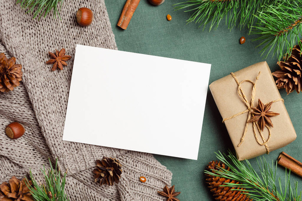 Kerst- of nieuwjaarskaart mockup met geschenkdoos, specerijen en dennenbomen takken met kegels - Foto, afbeelding