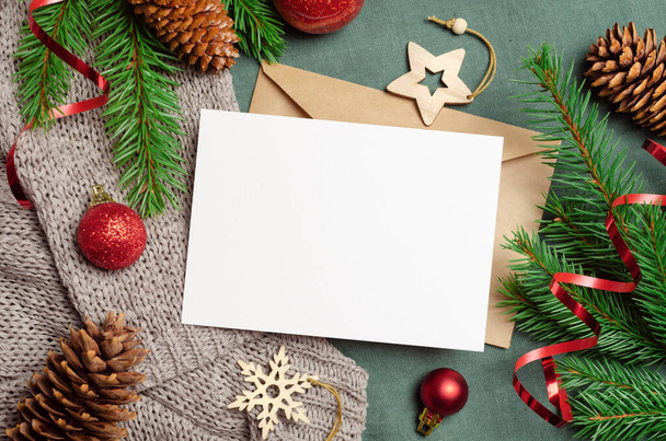 Christmas or New Year greeting card mockup with envelope and festive decorations with fir tree branches - Foto, imagen