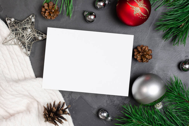 Tarjeta de felicitación navideña maqueta plana con decoraciones festivas y ramas de pino con conos - Foto, imagen