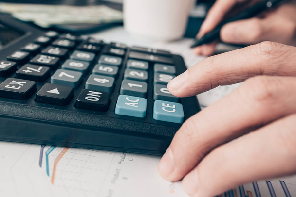 Pénzügyi üzletember, aki irodai munkát végez, számológépet használ a társasági adóra vonatkozó adatok kiszámításához és a pénzügyi kimutatások elemzéséhez. pénzügyi és számviteli koncepció. - Fotó, kép