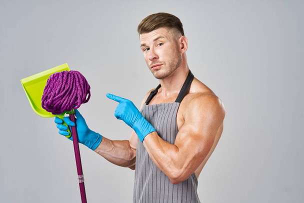 pumped up cleaner in aprons with a mop in the hands of providing services - Foto, Bild