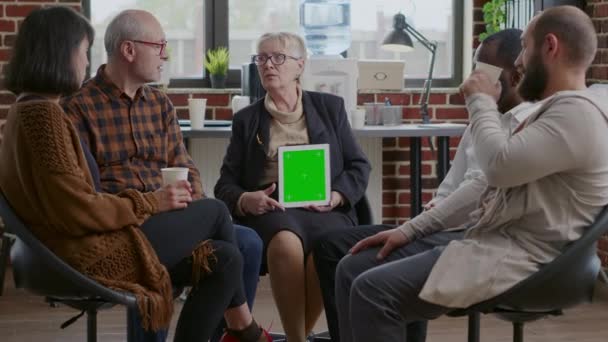 Psychotherapeut en patiënten die naar het groene scherm op digitale tablet kijken, wonen een vergadering bij. - Video