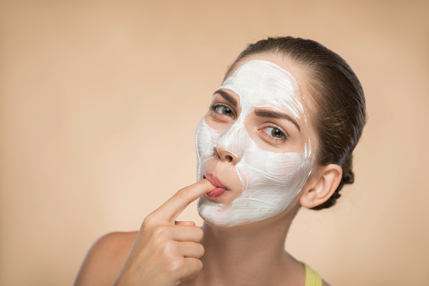 Girl applying facial cream mask - Фото, изображение