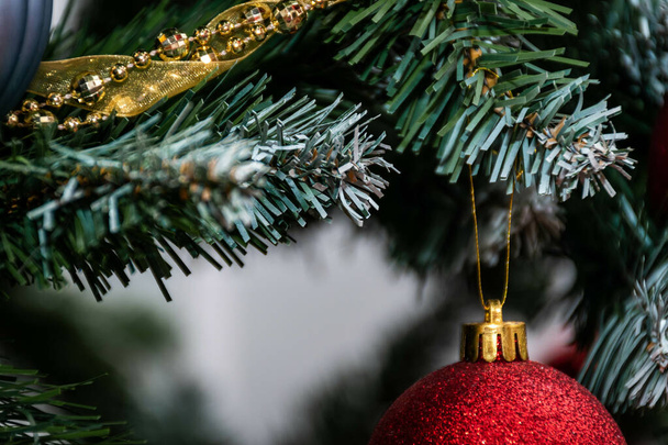 A closeup shot of a red big ball hanging on a Christmas tree - Foto, Bild