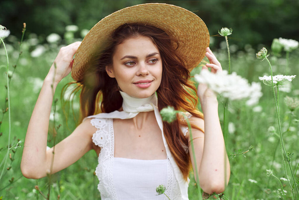 pretty woman in white dress and hat posing flowers nature - Zdjęcie, obraz
