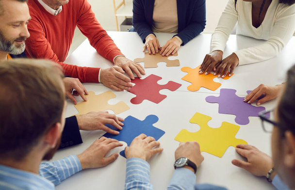 Diverse multiethnic people group collaborating assembling puzzle pieces together - Photo, Image