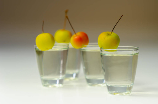 Deliciosos Calvados servidos en vasos de chupito decorados con manzanas de cangrejo, una bebida alcohólica hecha de manzanas y peras - Foto, imagen