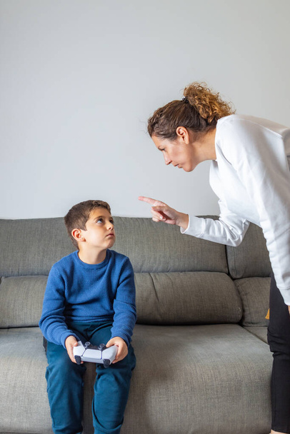 Мати сердиться на сина, тому що він грає у відеоігри
 - Фото, зображення