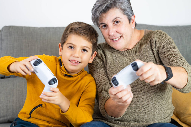 A kisfiú és a nagyanyja videojátékoznak. - Fotó, kép