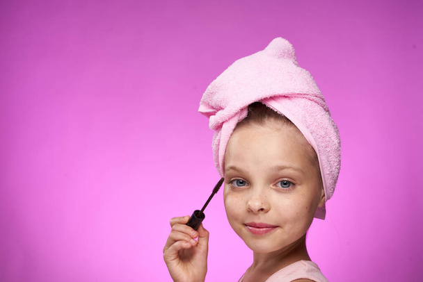 girl with a towel on her head cosmetics decoration close-up purple background - Foto, Imagem