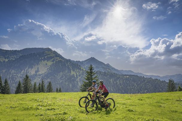 agradável e permaneceu jovem avó e seu neto montando suas bicicletas de montanha electrc nos Alpes Allgaeu perto de Oberstaufen, na Baviera, Alemanha - Foto, Imagem
